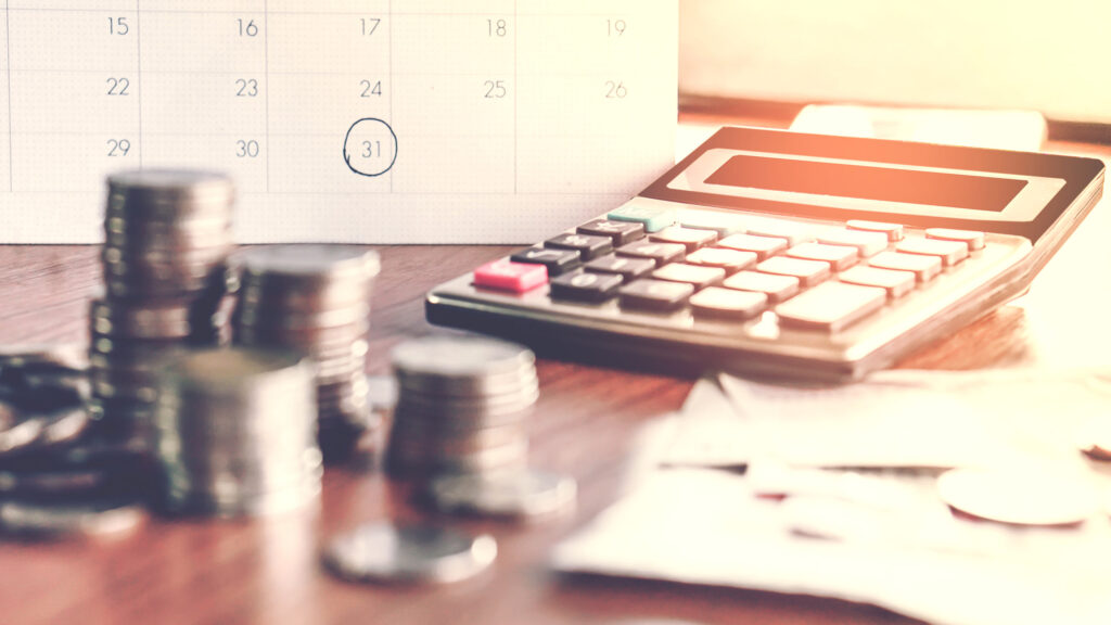 A calendar, calculator, and coins, representing correcting a tax return in Texas.